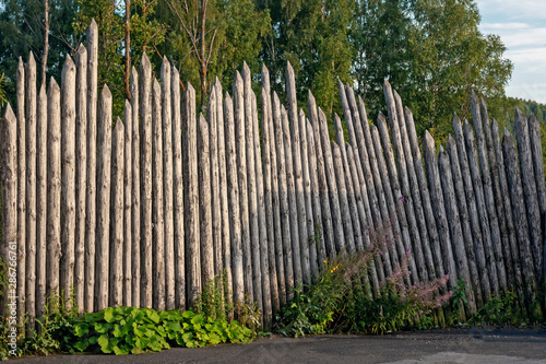 Fototapeta Naklejka Na Ścianę i Meble -  a very old wooden fence made of logs is a good example of ancient architecture