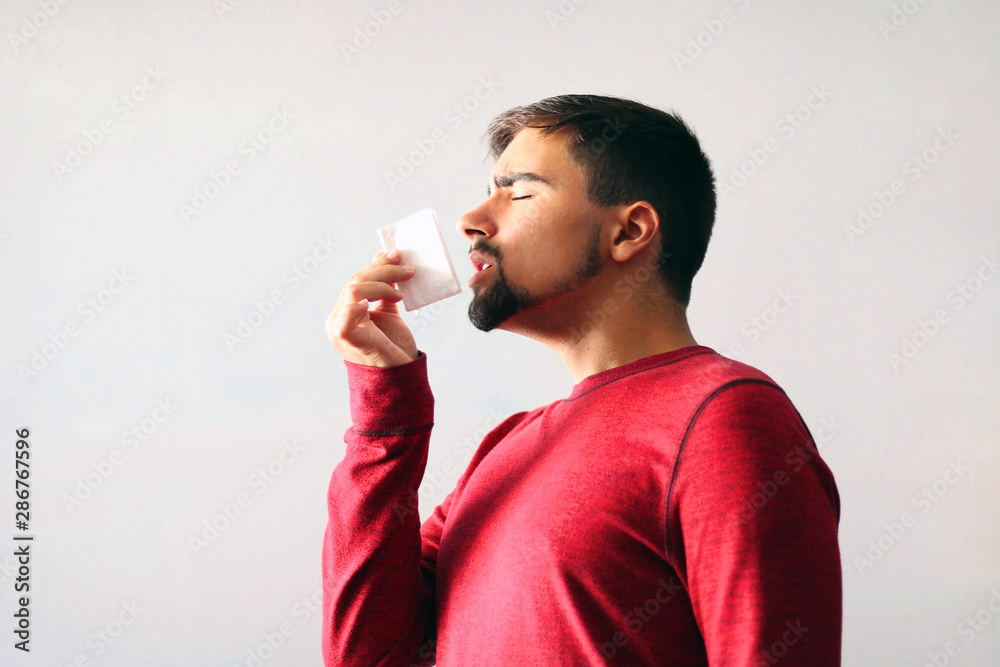 Health and Medicine Concept: Man dressed in red blowing his nose. Cold boy. Health and Medicine Concept: Man dressed in red blowing his nose. Cold boy.