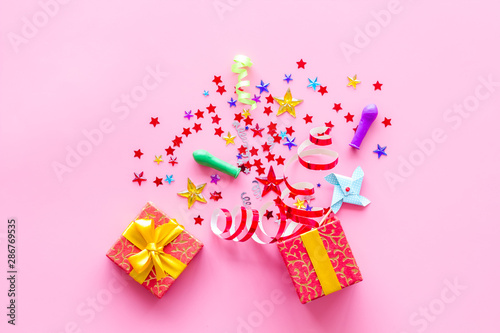 party time concept with decorations in box on pink background top view