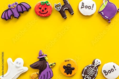 Halloween decorations frame on yellow background top view copyspace