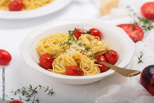 Italian pasta spaghetti with fried cherry tomato and thyme, close up shot