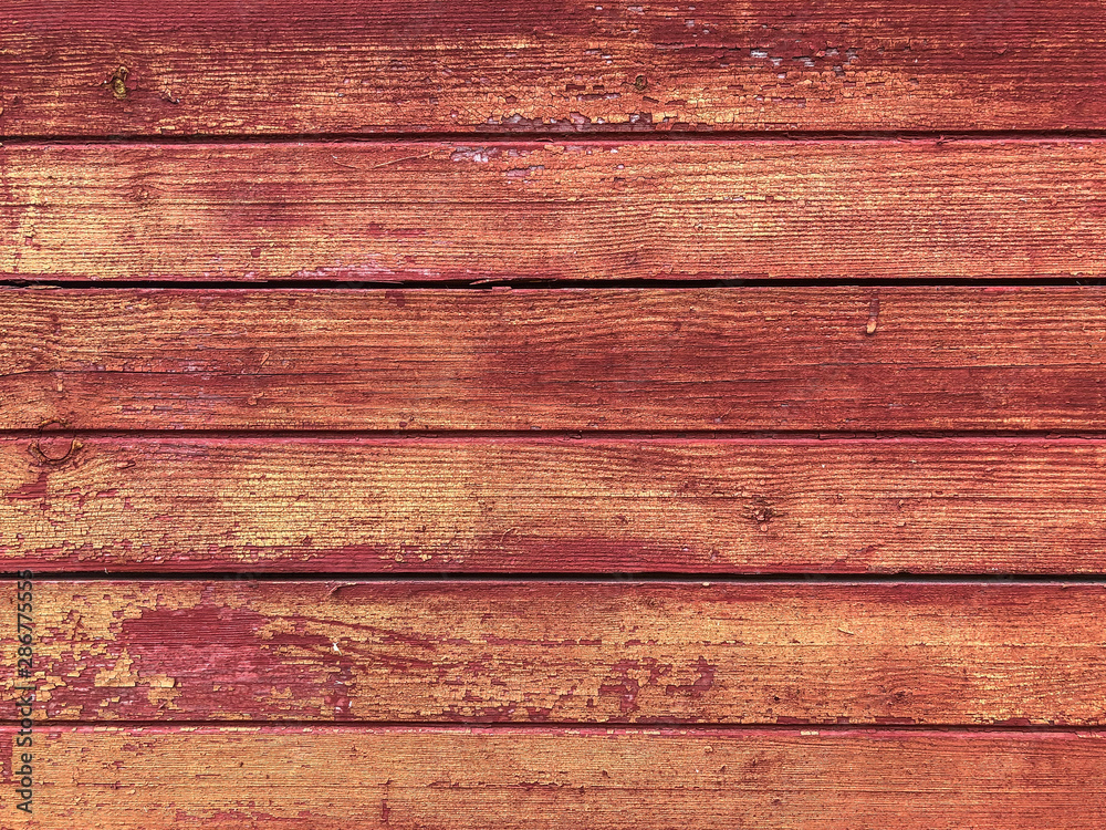 Wood background with red paint. Old paint on a wooden surface. Wall boards made of wood. Floor, closeup texture.