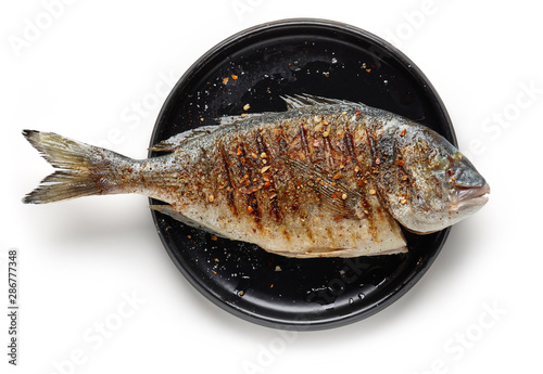 Photography Grilled fish on black plate