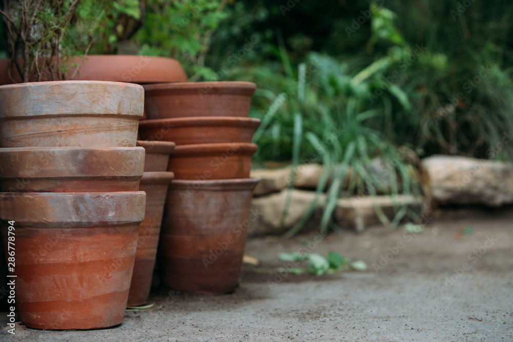 Naklejka premium Used old empty terracotta/clay flower pots in the garden, close up. 