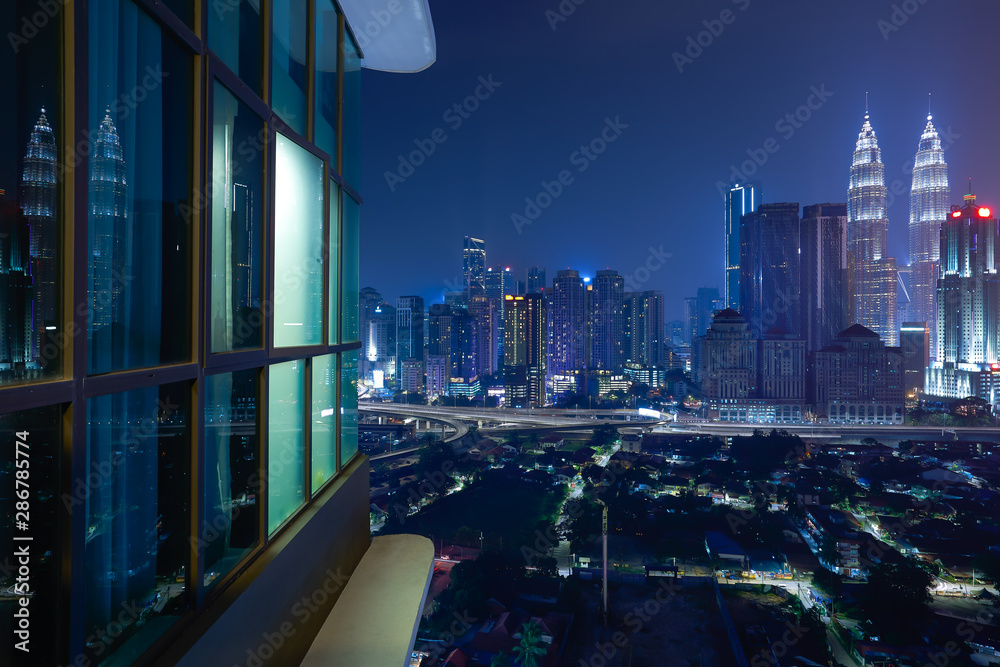 Fototapeta premium Night view of a beautiful cityscape with window reflection