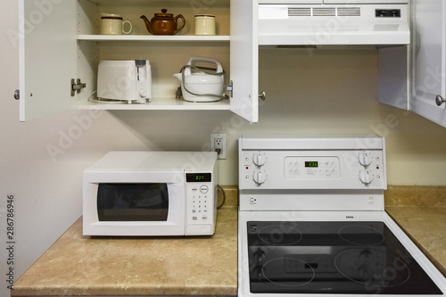 Open cabinets and primary appliances on average home kitchen.