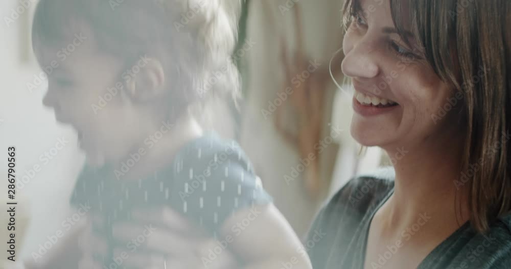 Mother playing with daughter at home on the couch. Real life, candid footage. Shot in 4K RAW on a cinema camera.
