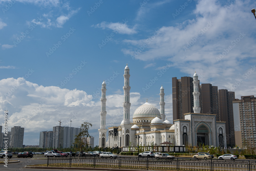 Obraz premium Hazret Sultan Mosque in the city of Nur Sultan. Beautiful white building of a mosque on a sunny day.