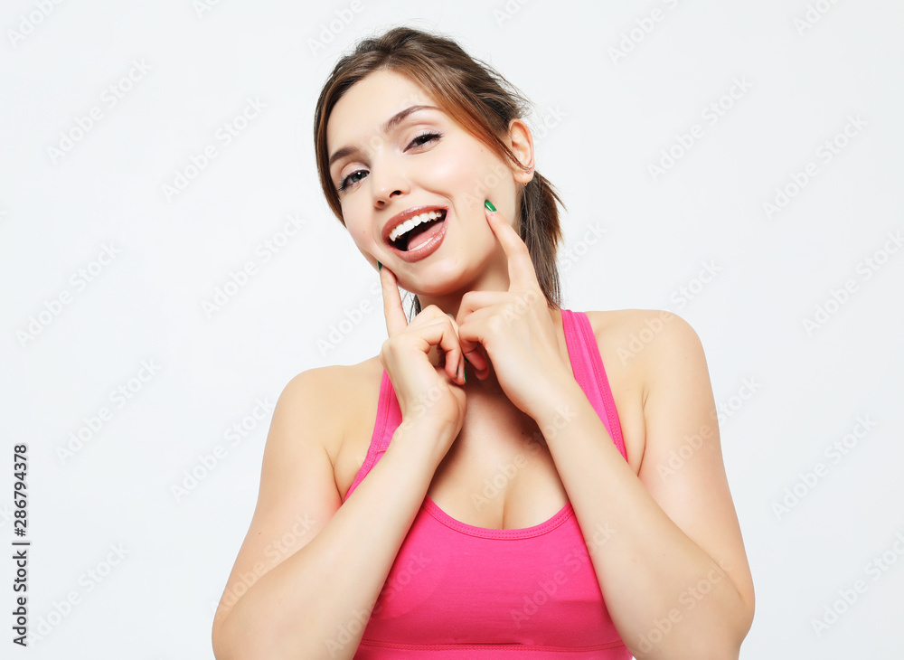 portrait of a smiling fitness woman in headphones working out isolated over white background portrait of a smiling fitness woman in headphones working out isolated over white background