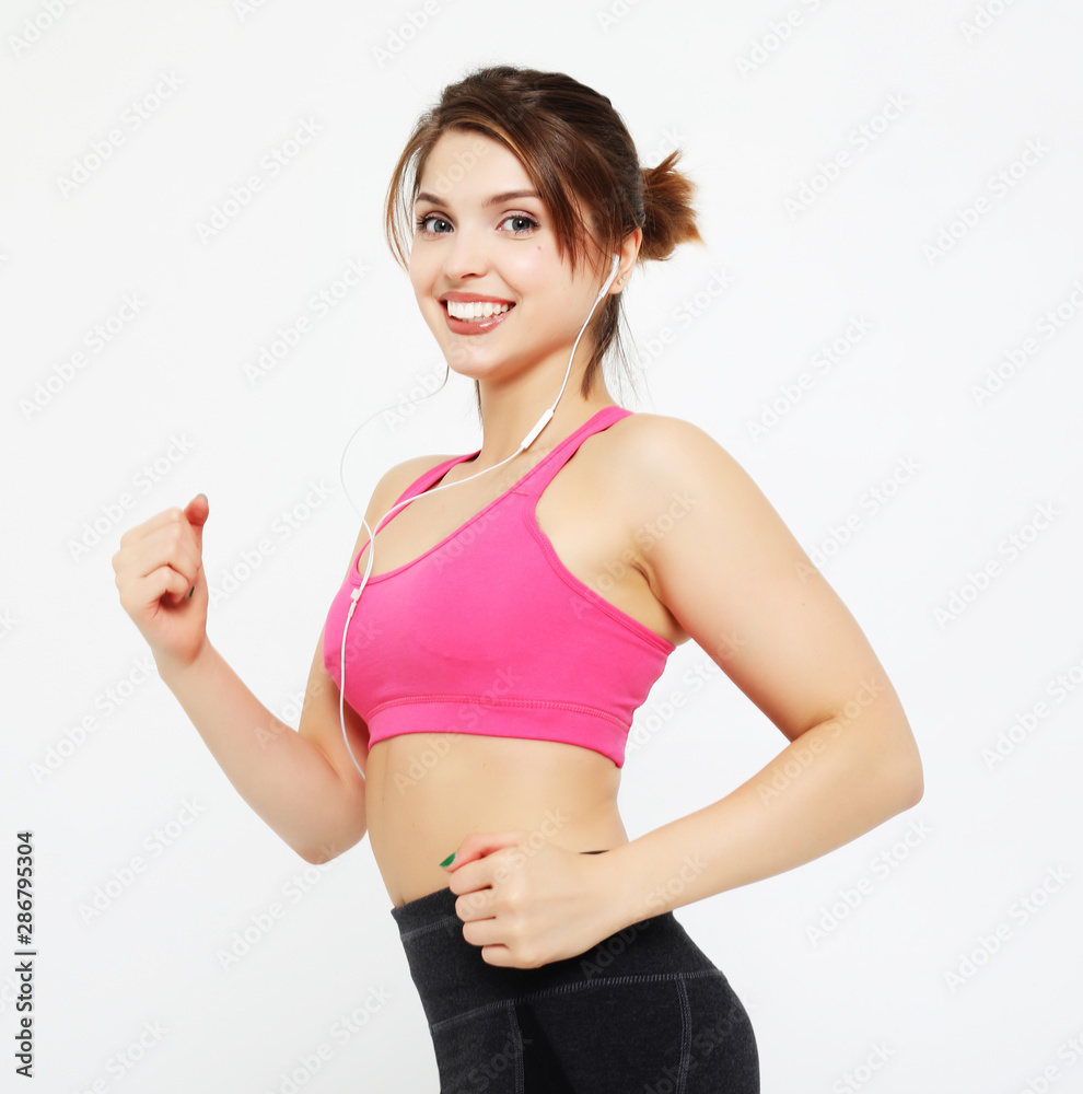 portrait of a smiling fitness woman in headphones working out isolated over white background portrait of a smiling fitness woman in headphones working out isolated over white background