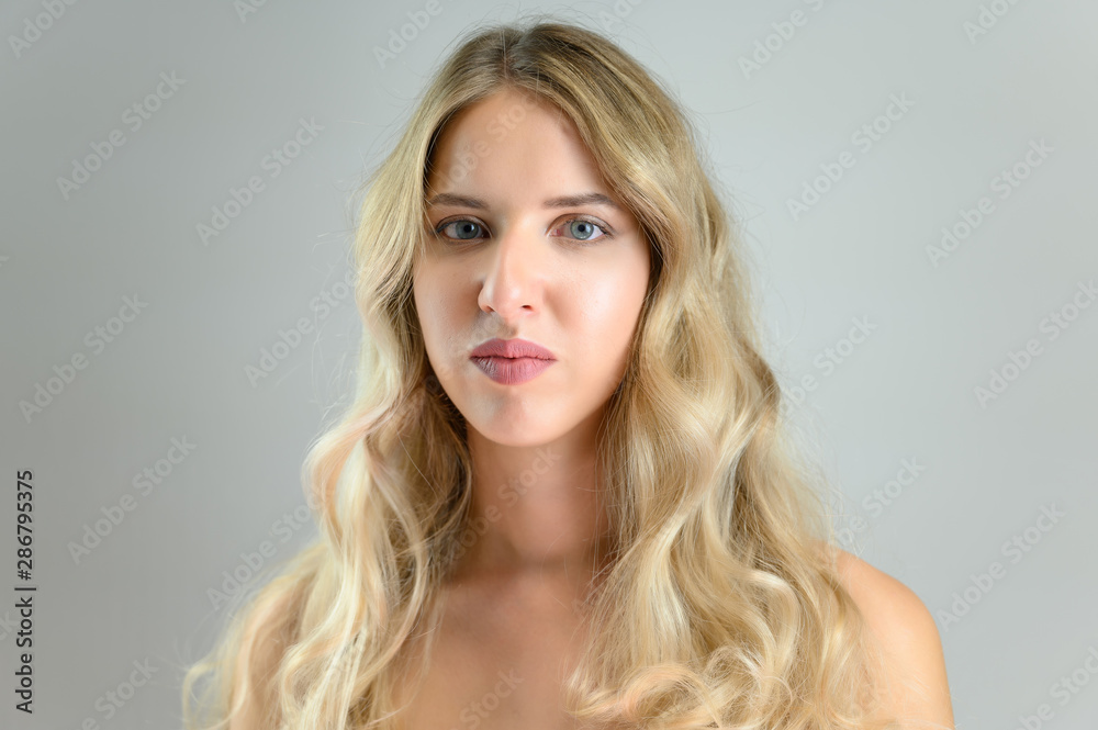 A large photo portrait of a pretty model with long hair and a beautiful hairstyle on a white background.