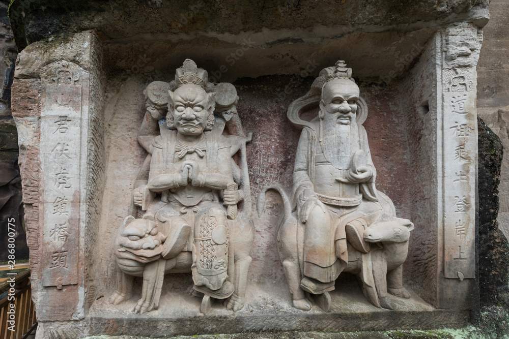 Reliefs of Laozi (Lao Tzu) or Supreme Lord (right) and Mountain God (left) at Dazu Rock Carvings at Mount Baoding or Baodingshan in Dazu, Chongqing, China. UNESCO World Heritage Site.