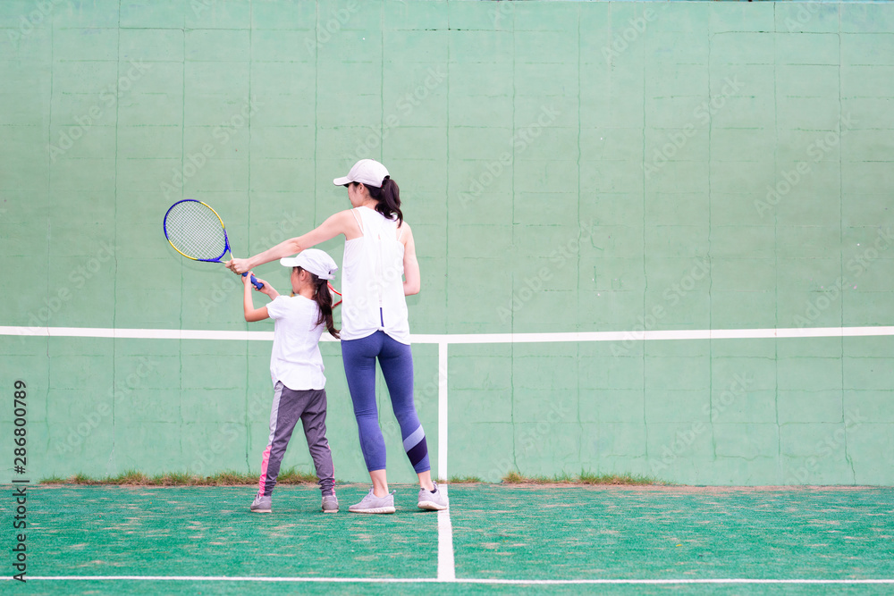 テニスの練習をする母と娘