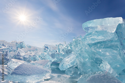 Beautiful winter landscape of the frozen Baikal Lake. A pile of transparent ice floes in hummock fields on a cold sunny day. Natural background, winter travel