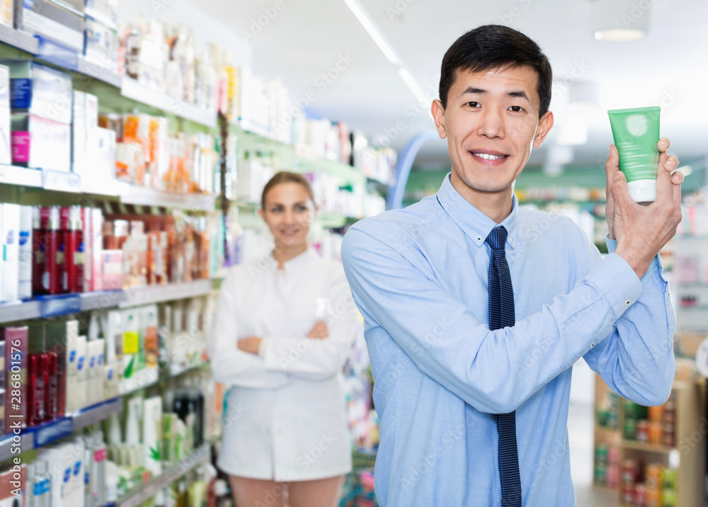 Portrait of korean man client who is satisfied of recommended medicines in pharmacy.