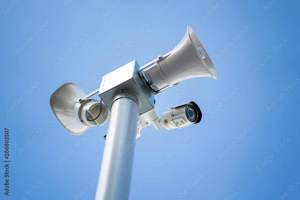 Security camera with loudspeakers and megaphone on the sky background Security camera with loudspeakers and megaphone on the sky background