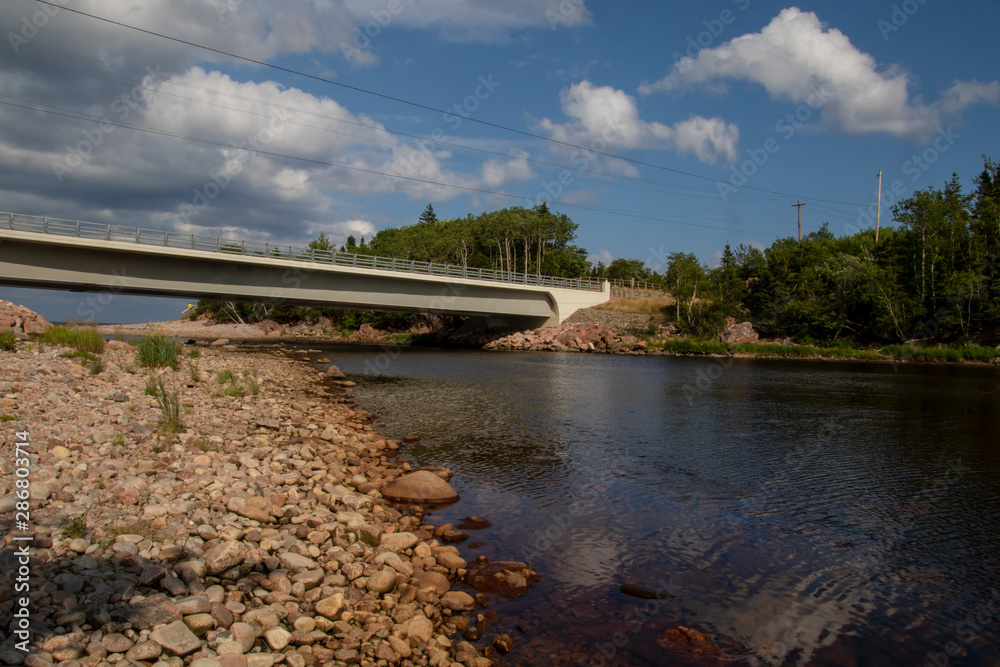 A bridge going over a river with forest on the right hand side A bridge going over a river with forest on the right hand side