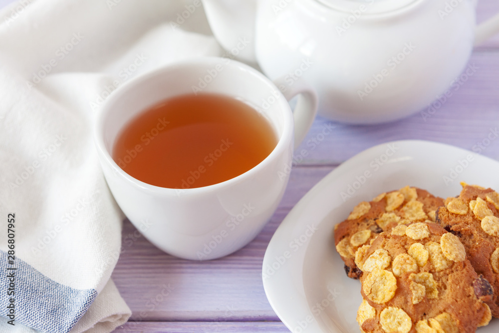 Cup of tea with cookies over lilac wooden background Cup of tea with cookies over lilac wooden background