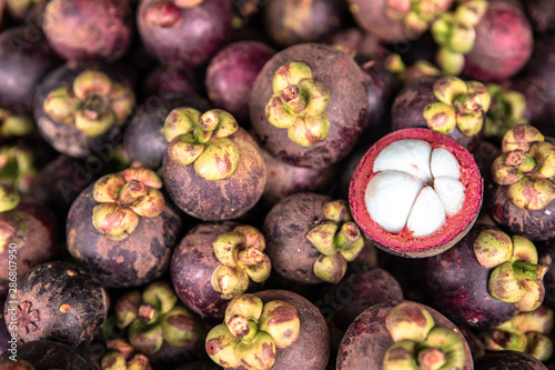 Mangosteen and cross section showing the thick purple skin and white flesh of the queen of friuts, Mangosteen flesh, closeup.