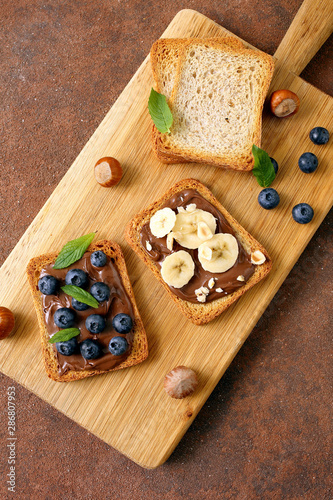 spuntino con cioccolato spalmabile su pane tostato con mirtlli e banane photo