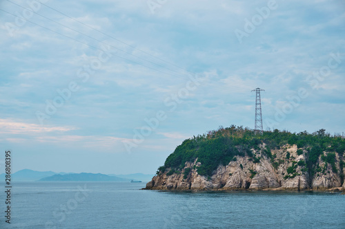 夕暮れ時の島の鉄塔と電線