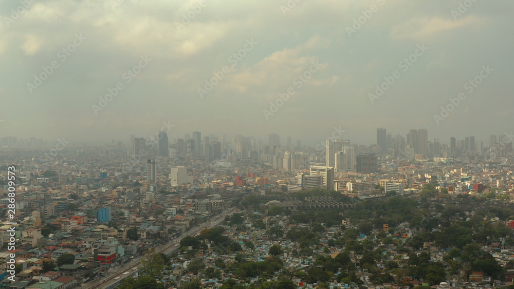 Manila North Cemetery and Cityscape of Makati, the business center of Manila, view from above. Asian metropolis. Travel vacation concept.