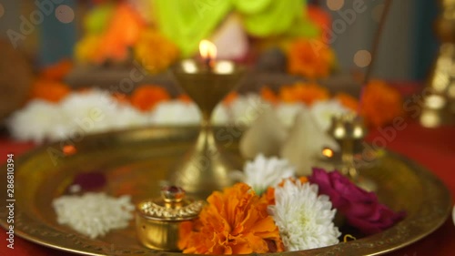 Close shot of a decorated temple for Ganesh Chaturthi - Modak  Lamp  Sweets  and Fruits. Pan shot of various items kept for worshipping Lord Ganesh in the temple - Puja thali  sweets  incense stick... photo