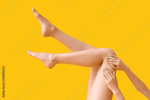 Young woman with slim legs on color background photo