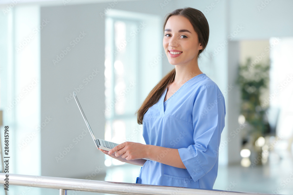 Young female student with laptop in clinic Young female student with laptop in clinic