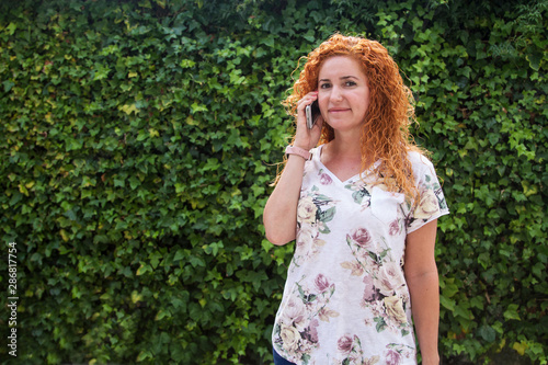 woman talking with her cellphone with green background