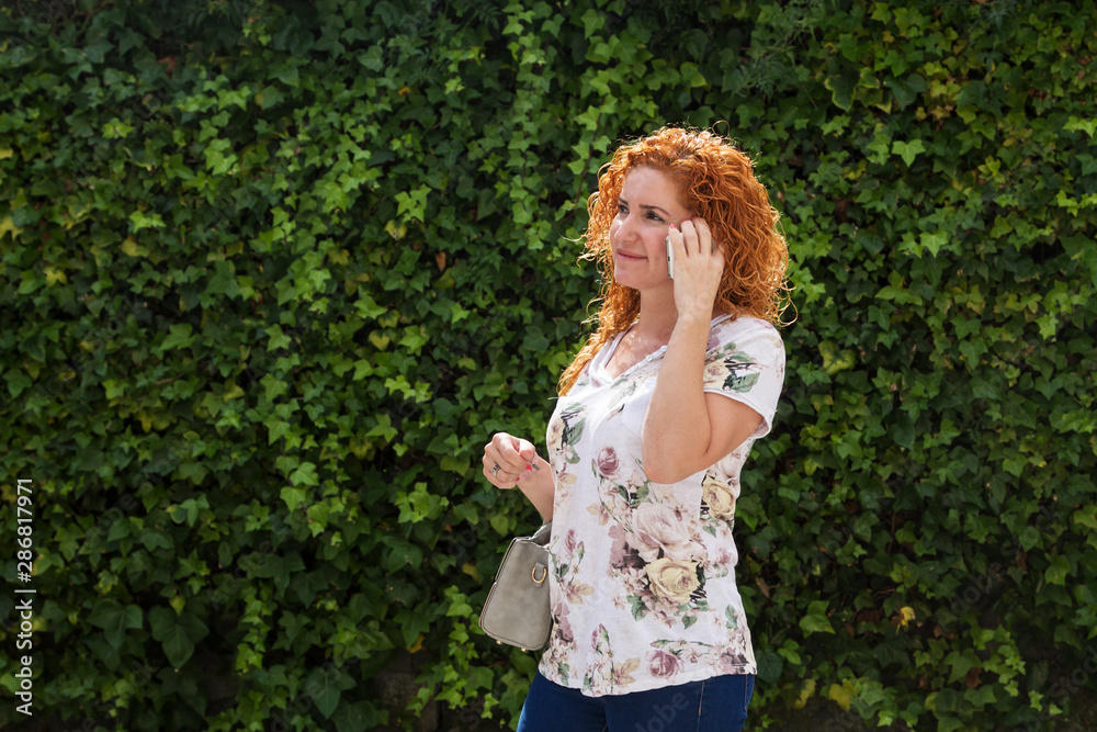 woman talking with her cellphone with green background woman talking with her cellphone with green background