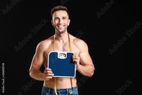 Smiling muscular man holdin...