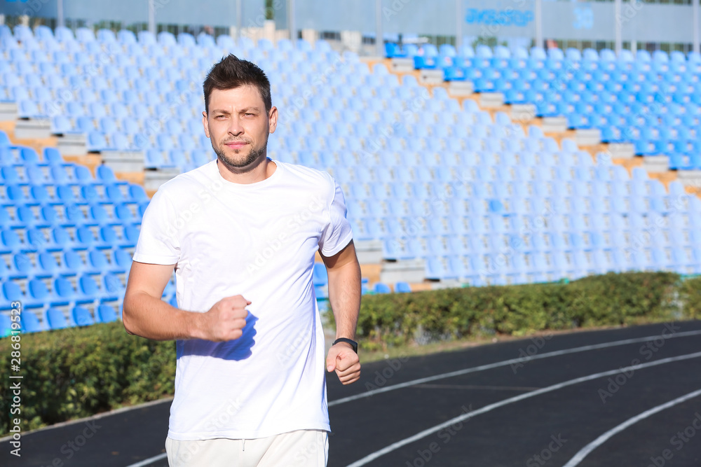 Sporty man running at the stadium