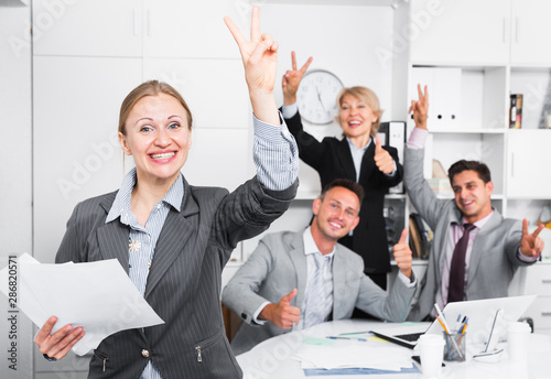 Happy team with businesswoman celebrating victory photo