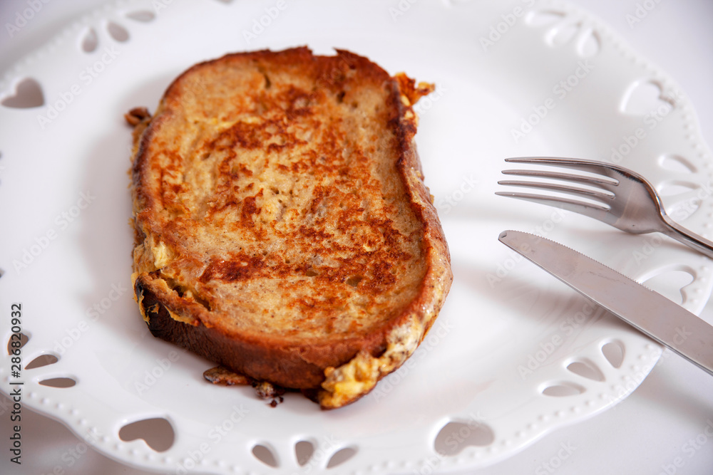 egg toast on white porcelain plate with heart (fried in hot oil) egg toast on white porcelain plate with heart (fried in hot oil)