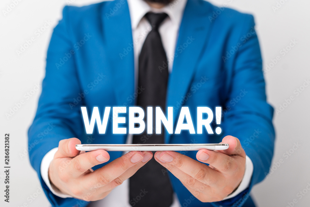 Handwriting text writing Webinar. Conceptual photo seminar or other presentation types that takes place on Internet Businessman in blue suite with a tie holds lap top in hands Handwriting text writing Webinar. Conceptual photo seminar or other presentation types that takes place on Internet Businessman in blue suite with a tie holds lap top in hands
