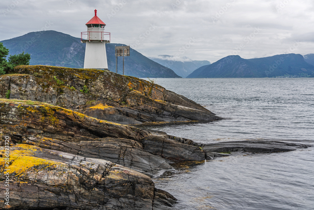 Lighthouse in Norwegian fjords, Norway. Sea mountain landscape view.
