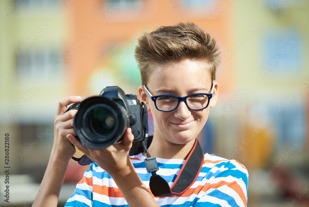 Funny teen boy with digital photo camera
