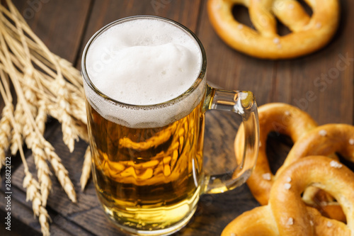 Photo A mug of lager beer with german pretzels.