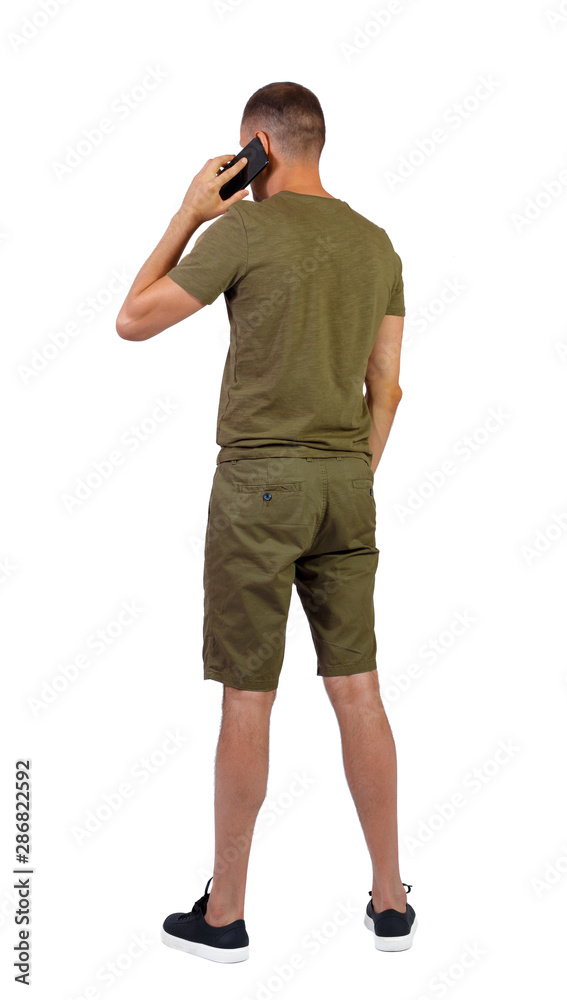 Back view of man in shorts with smartphone. Back view of man in shorts with smartphone.