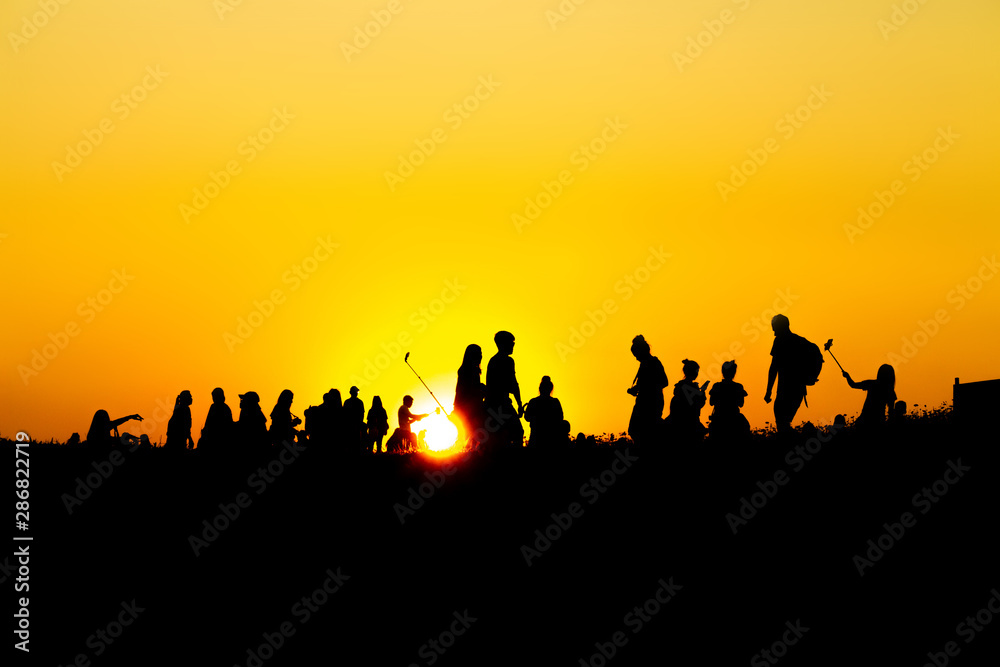 Silhouette of many tourists are taking pictures by smart phone on the top of the mountain during sunset times. Silhouette of many tourists are taking pictures by smart phone on the top of the mountain during sunset times.