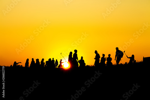 Silhouette of many tourists are taking pictures by smart phone on the top of the mountain during sunset times. © BNMK0819