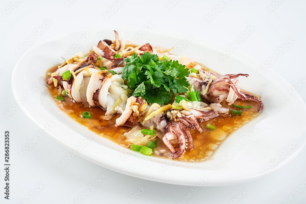 Chinese Cantonese cuisine home cooking, a dish of garlic steamed tubule squid on a white background Chinese Cantonese cuisine home cooking, a dish of garlic steamed tubule squid on a white background