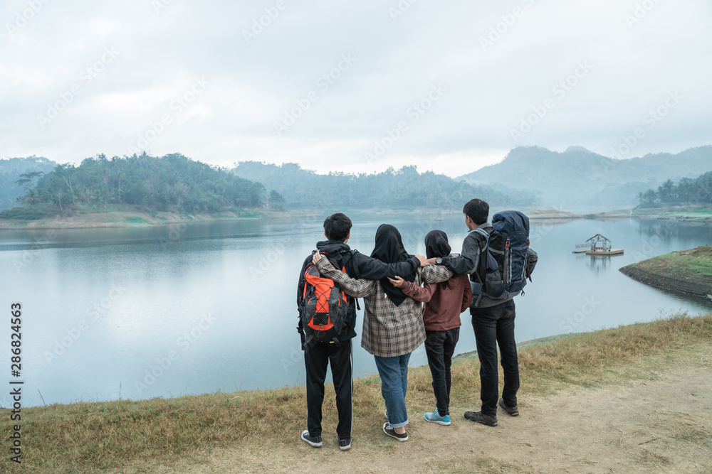 travelers with backpacks overlooking enjoy lake view travelers with backpacks overlooking enjoy lake view