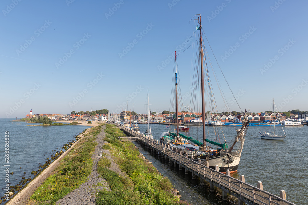 Historic sailing ship moored at pier of Dutch village Urk
