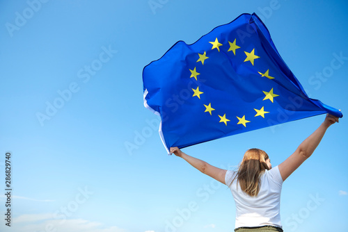 Rear view of young woman waving the European Union flag