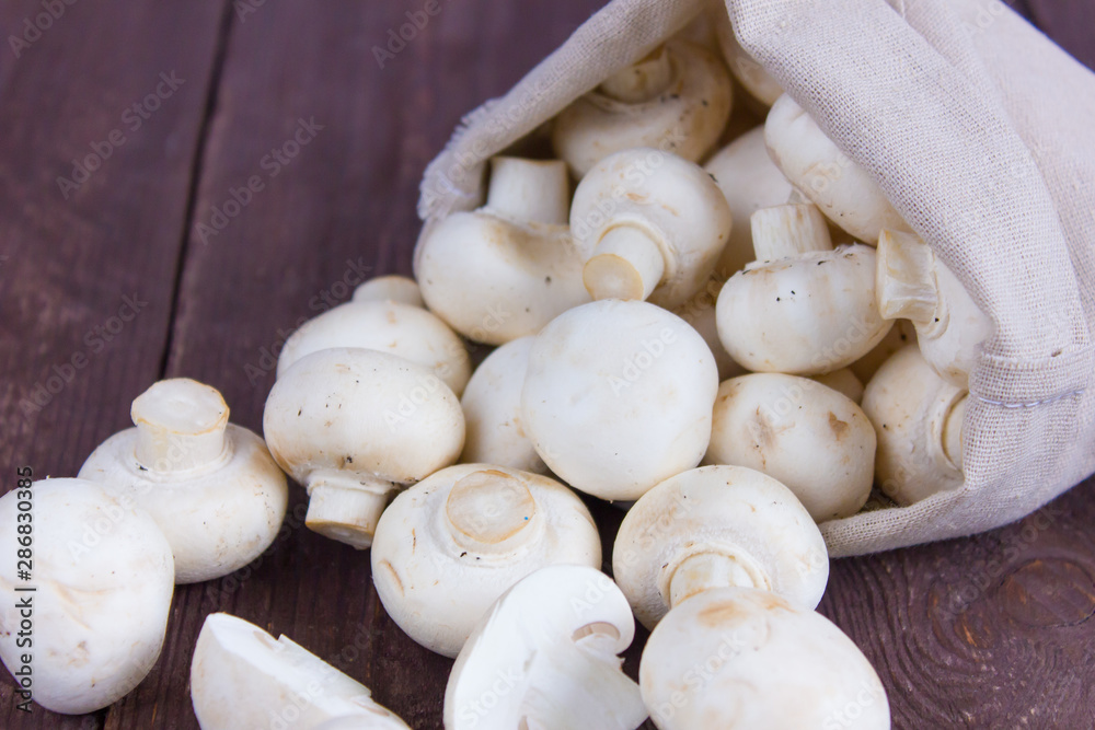 Champignon mushrooms in a bag on a dark background Champignon mushrooms in a bag on a dark background