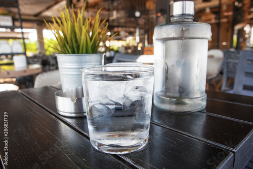 Water bottle woth glass on the table of cafe in Athens seaside, Greese photo