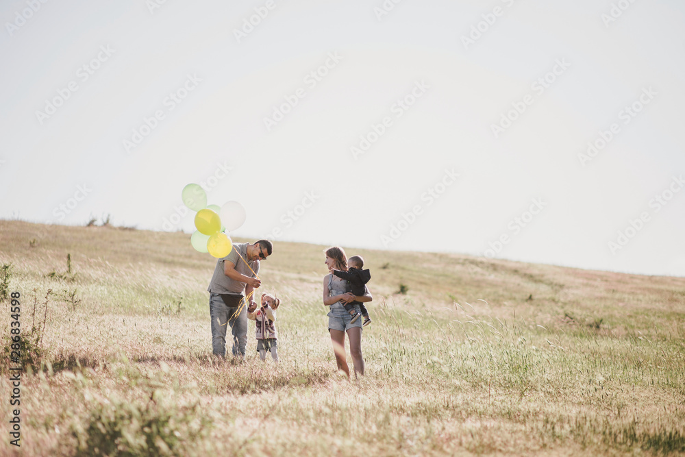 Happy family having fun on sunny meadow.