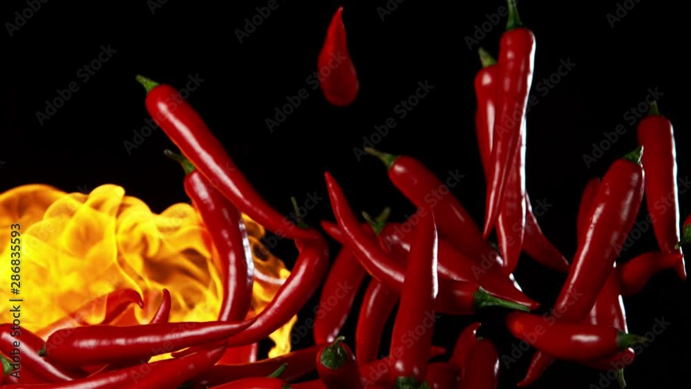 Super slow motion of flying red hot chilli peppers in fire. Filmed on high speed cinema camera, 1000 fps